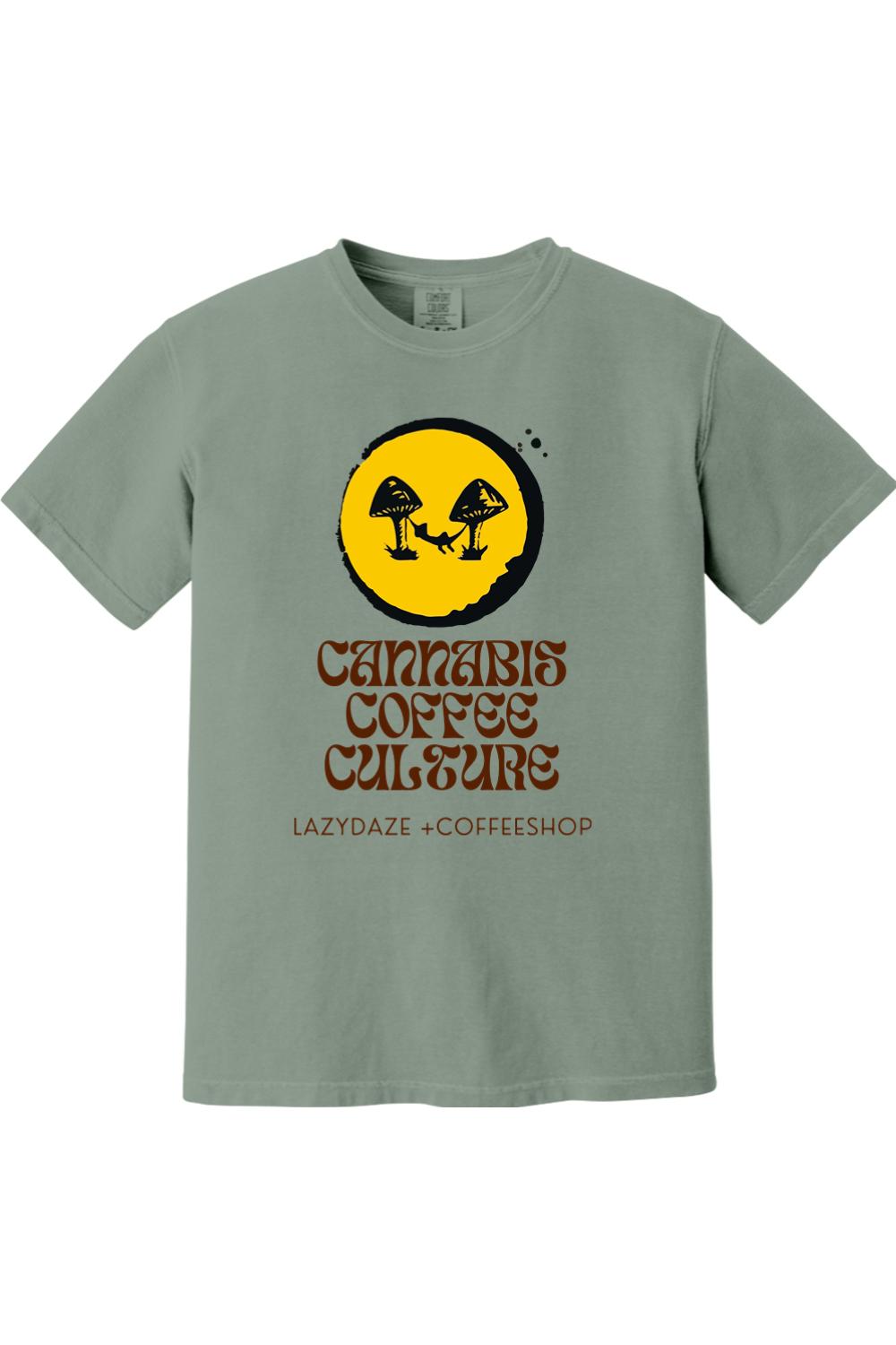 Sage green garment-dyed cotton t-shirt featuring a yellow circle graphic with mushroom and coffee shop text.