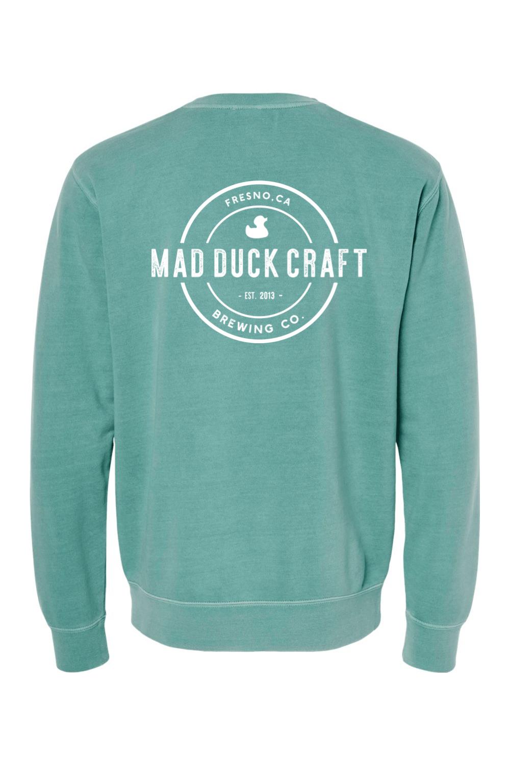 Seafoam green pigment-dyed crewneck sweatshirt featuring a white Mad Duck Craft Brewing Co. logo on the back.