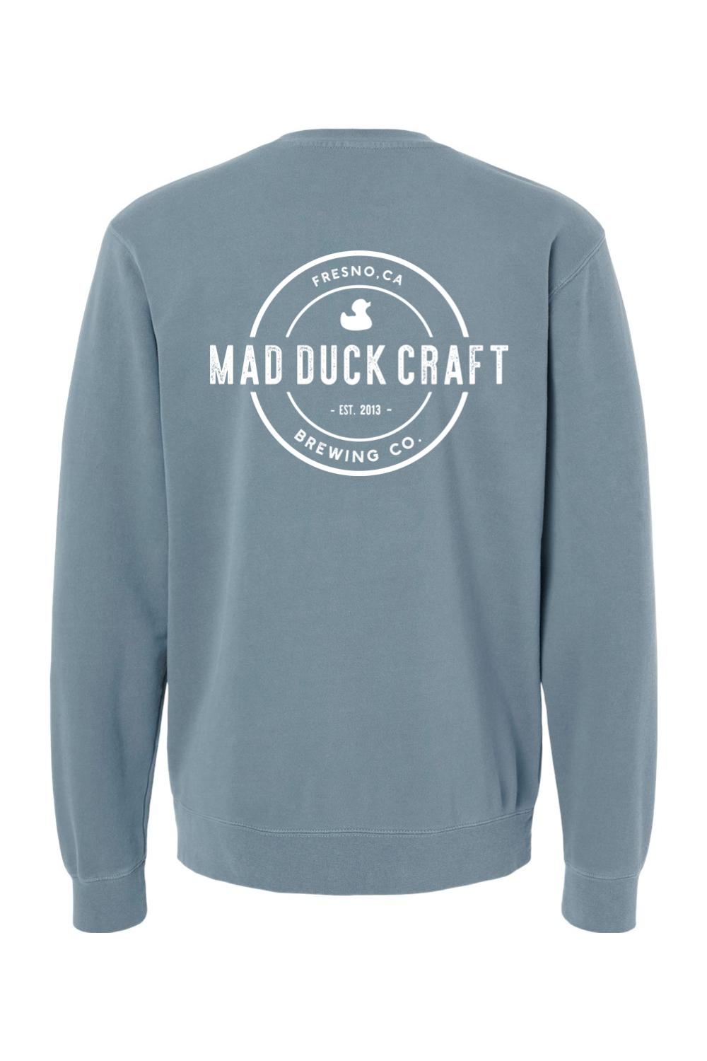 Blue pigment-dyed crewneck sweatshirt featuring a white Mad Duck Craft Brewing Co. logo on the back.