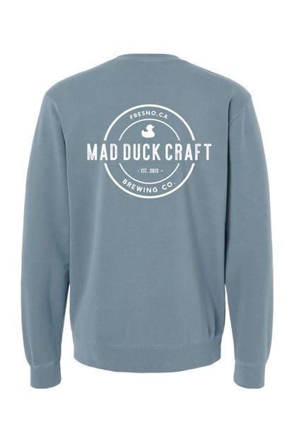 Blue pigment-dyed crewneck sweatshirt featuring a white Mad Duck Craft Brewing Co. logo on the back.