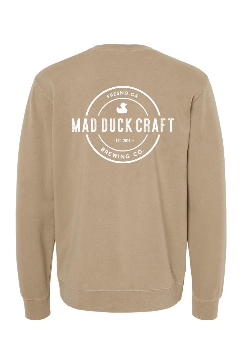 Tan pigment-dyed crewneck sweatshirt featuring a white Mad Duck Craft Brewing Co. logo on the back.