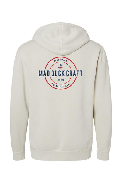 Off-white pigment-dyed hoodie featuring a red, white, and blue Mad Duck Craft Brewing Co. logo on the back.