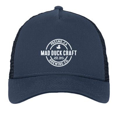 Navy blue New Era trucker cap with a white Mad Duck Craft Brewing logo, cotton twill front, and mesh back panels.
