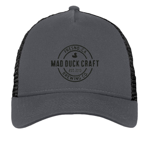 Grey 5-panel New Era trucker cap with black mesh back and embroidered Mad Duck Craft Brewing logo on the front.