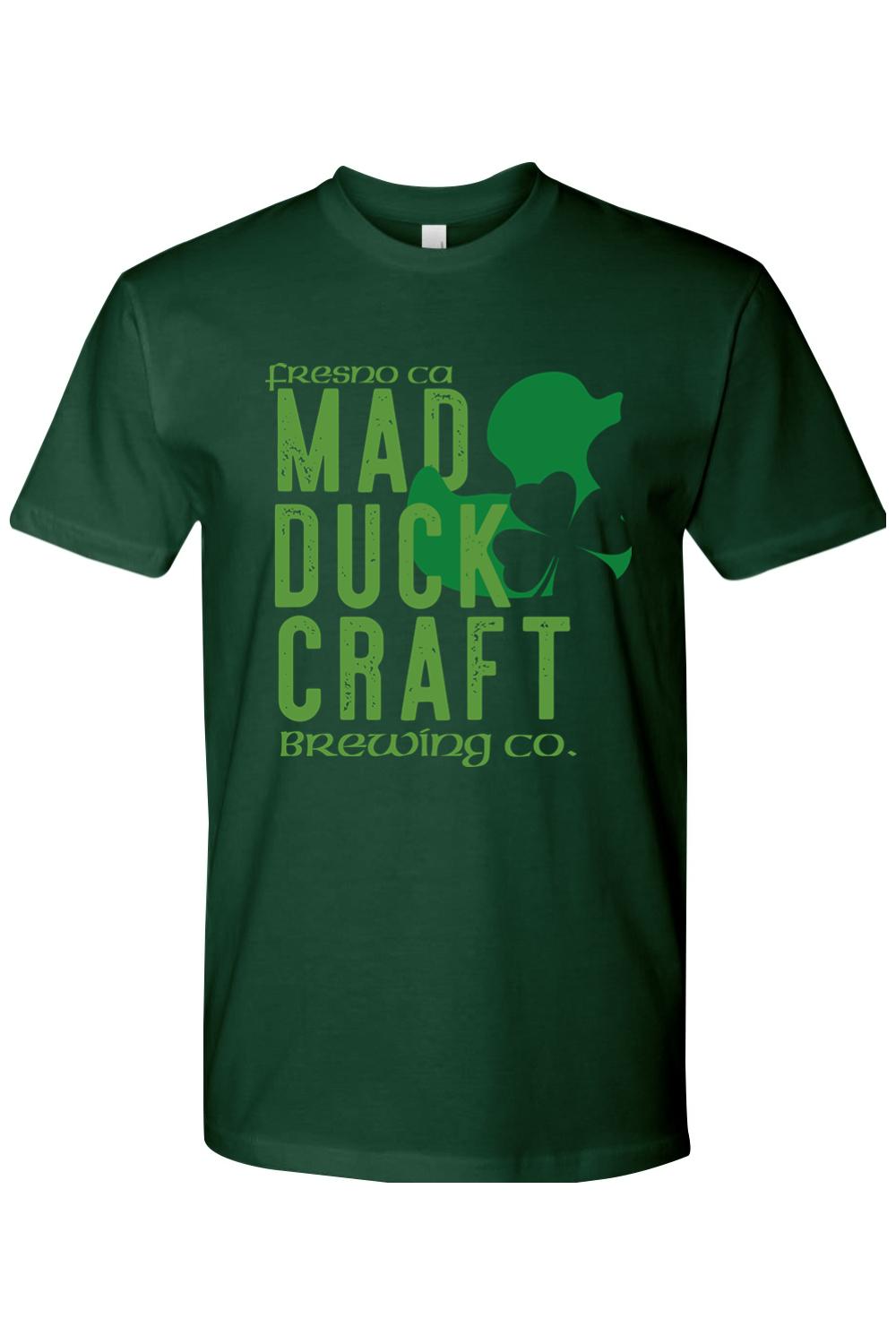 Dark green premium cotton t-shirt featuring a light green Mad Duck Craft Brewing Co. logo and shamrock graphic.