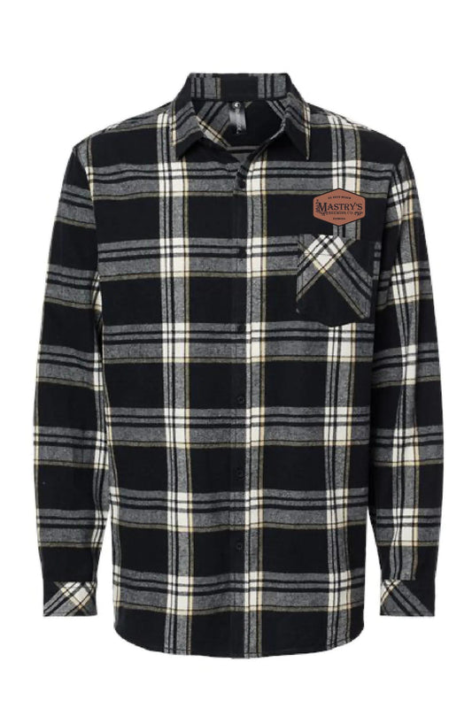 Black and grey plaid flannel shirt with a Mastry’s Brewing Co. leather chest patch and button-down front.
