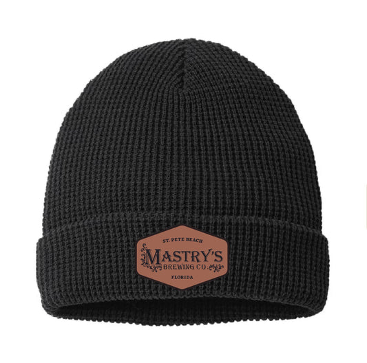 Black acrylic chunky waffle knit beanie with a brown leather patch featuring the Mastry’s Brewing Co. logo.