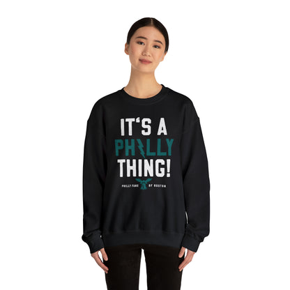 Woman wearing a black unisex heavy blend crewneck sweatshirt with It's a Philly Thing graphic print.