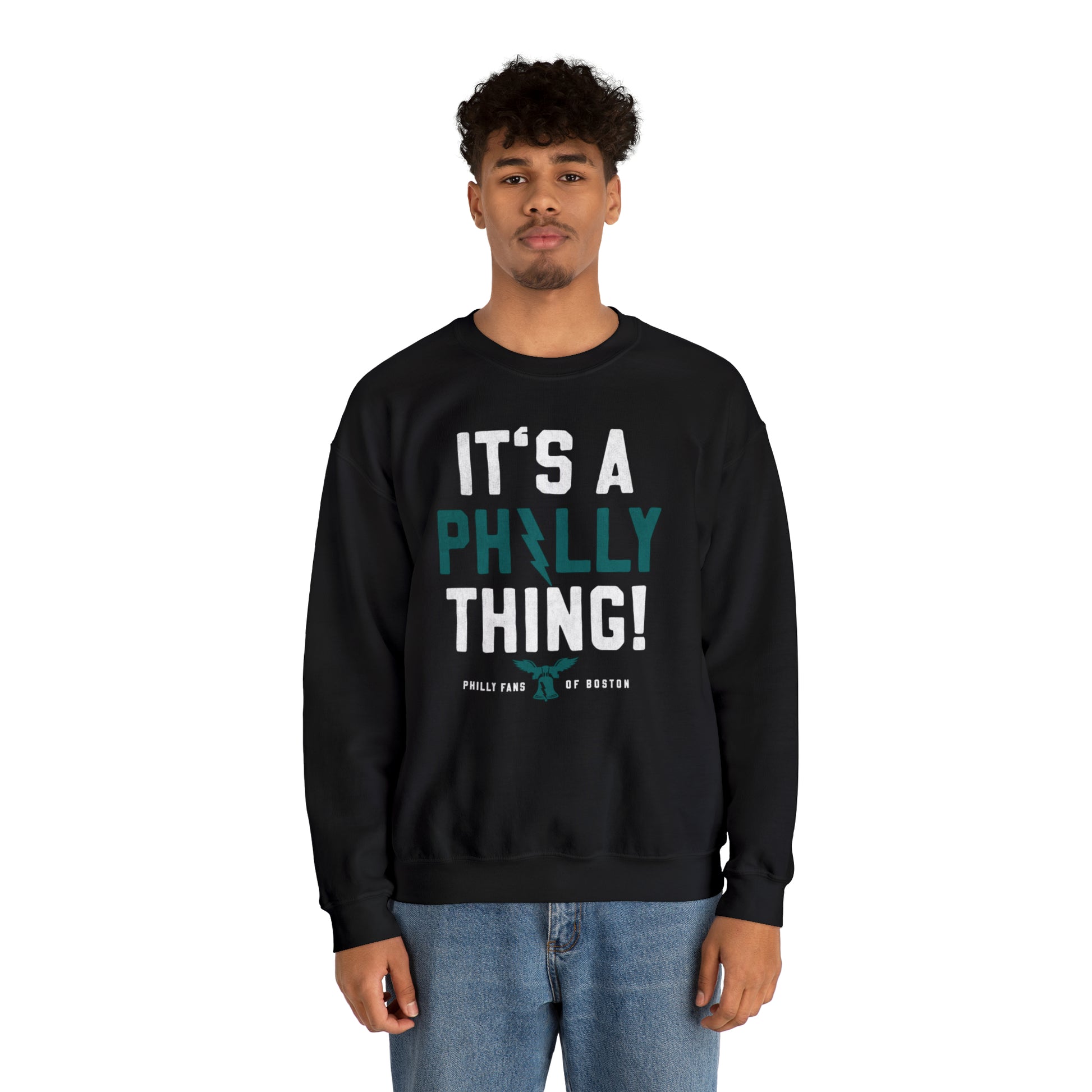 Man wearing a black heavy blend crewneck sweatshirt with It's A Philly Thing graphic print in white and teal.