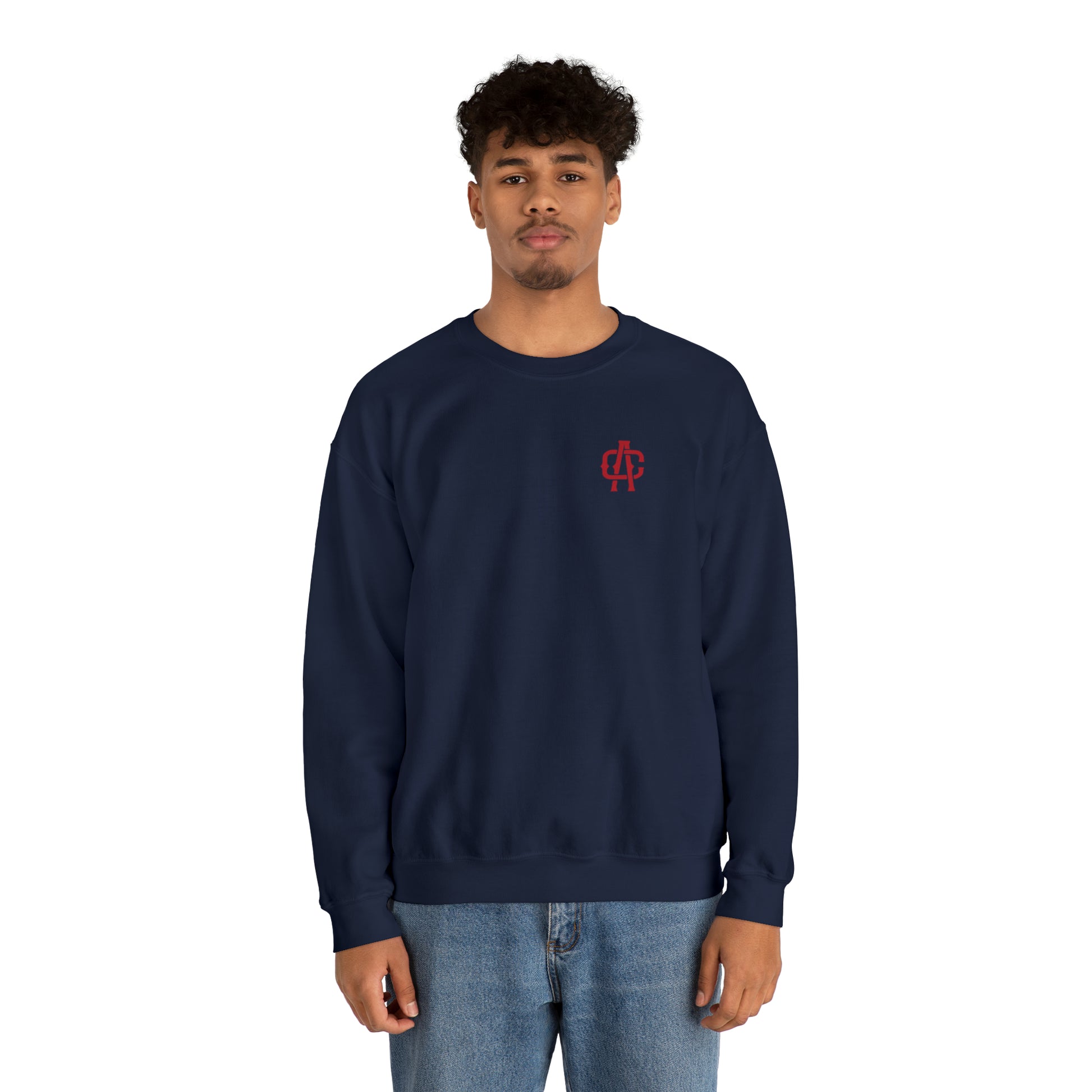 Man wearing a navy blue heavy blend crewneck sweatshirt with a small red logo on the chest.