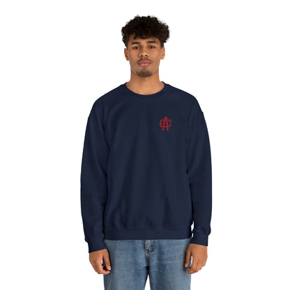 Man wearing a navy blue heavy blend crewneck sweatshirt with a small red logo on the chest.