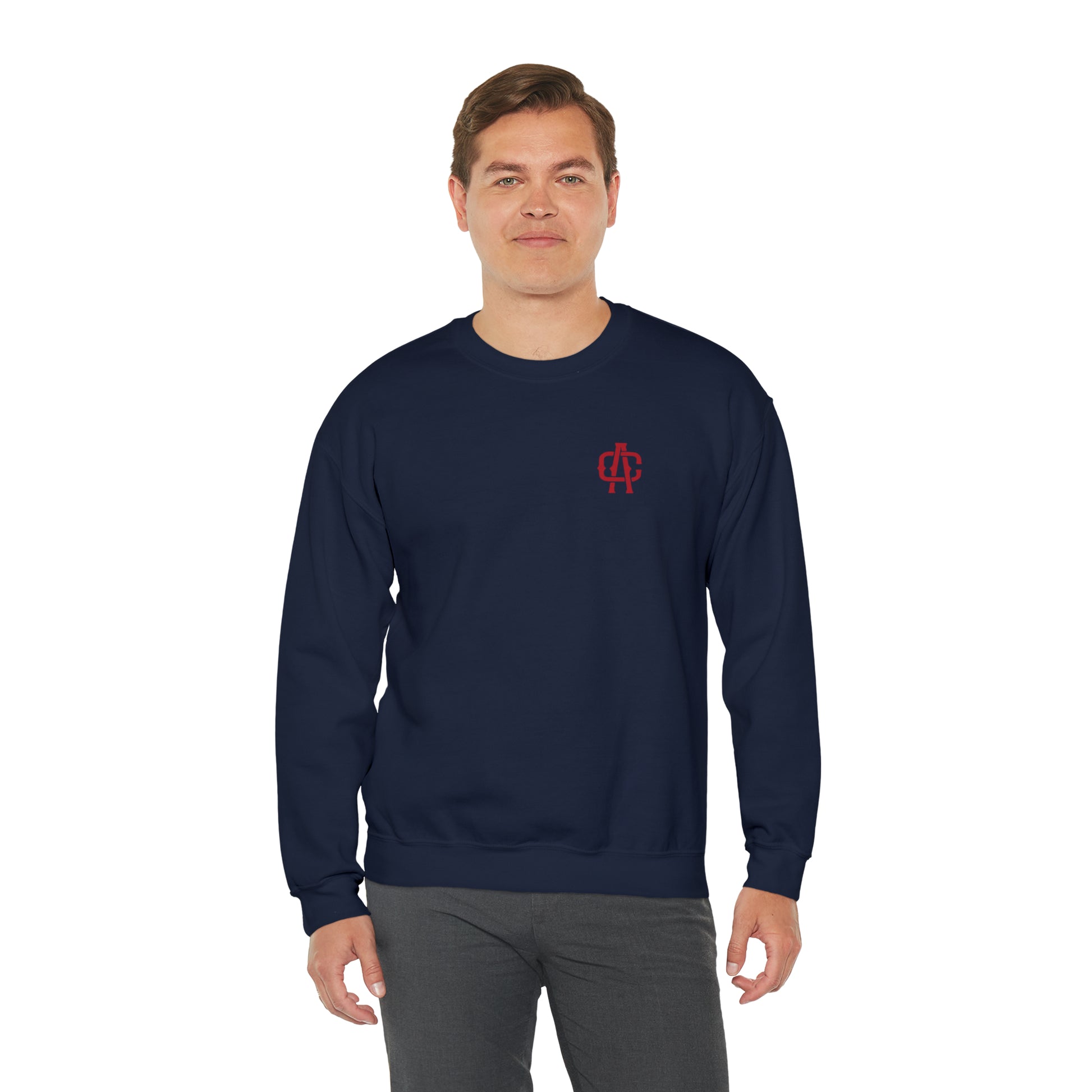 Man wearing a navy blue heavy blend crewneck sweatshirt with a small red logo on the chest.