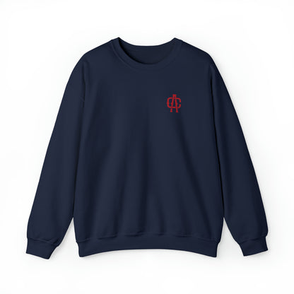 Navy blue crewneck sweatshirt with a red embroidered monogram logo on the left chest, featuring a ribbed knit collar.