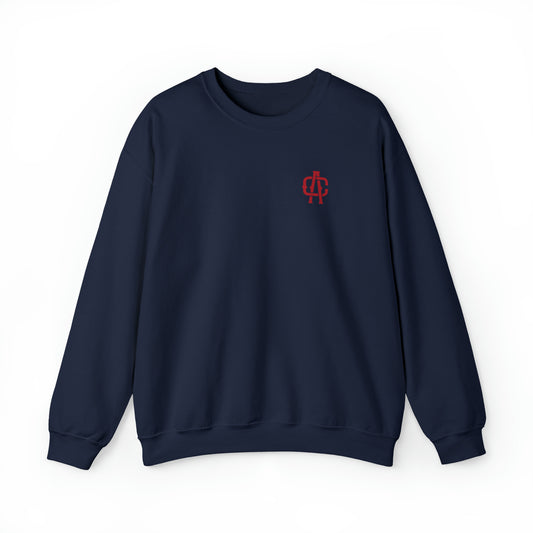 Navy blue crewneck sweatshirt with a red embroidered monogram logo on the left chest, featuring a ribbed knit collar.