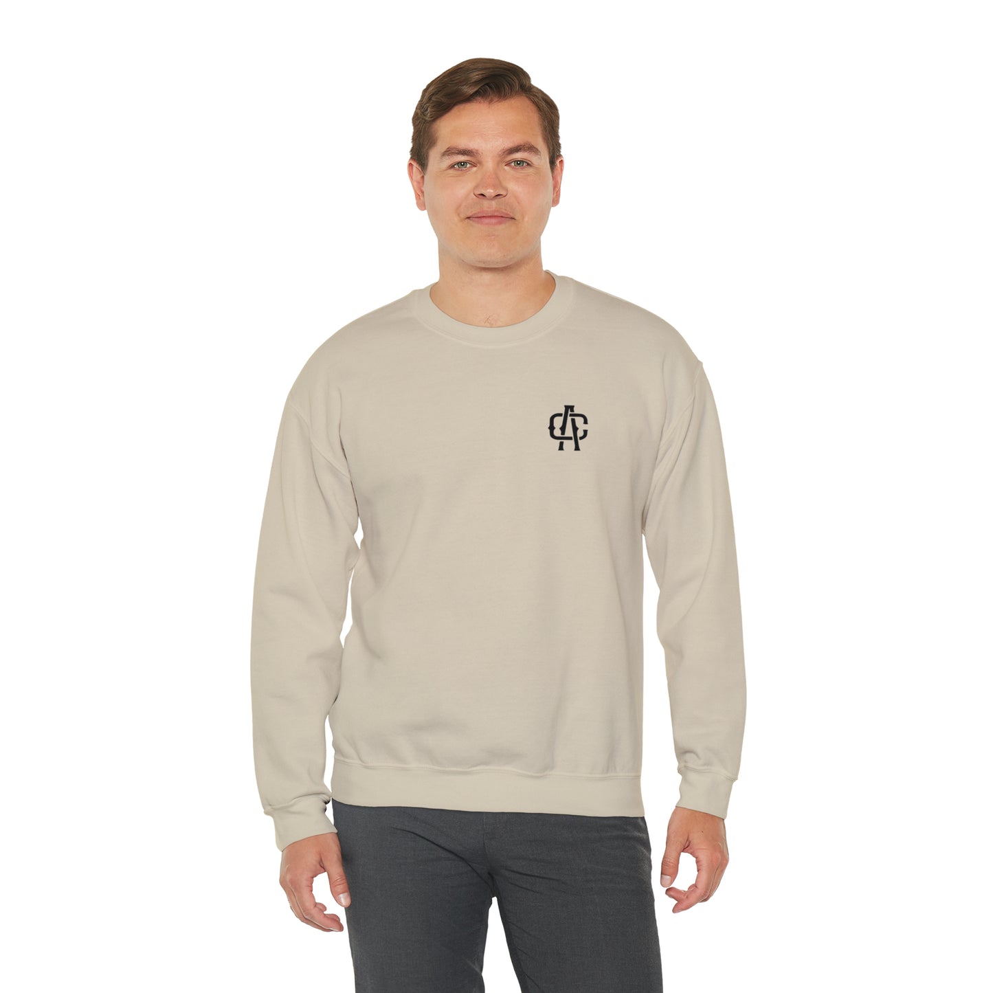 Man wearing a sand-colored heavy blend crewneck sweatshirt with a small black logo on the left chest.