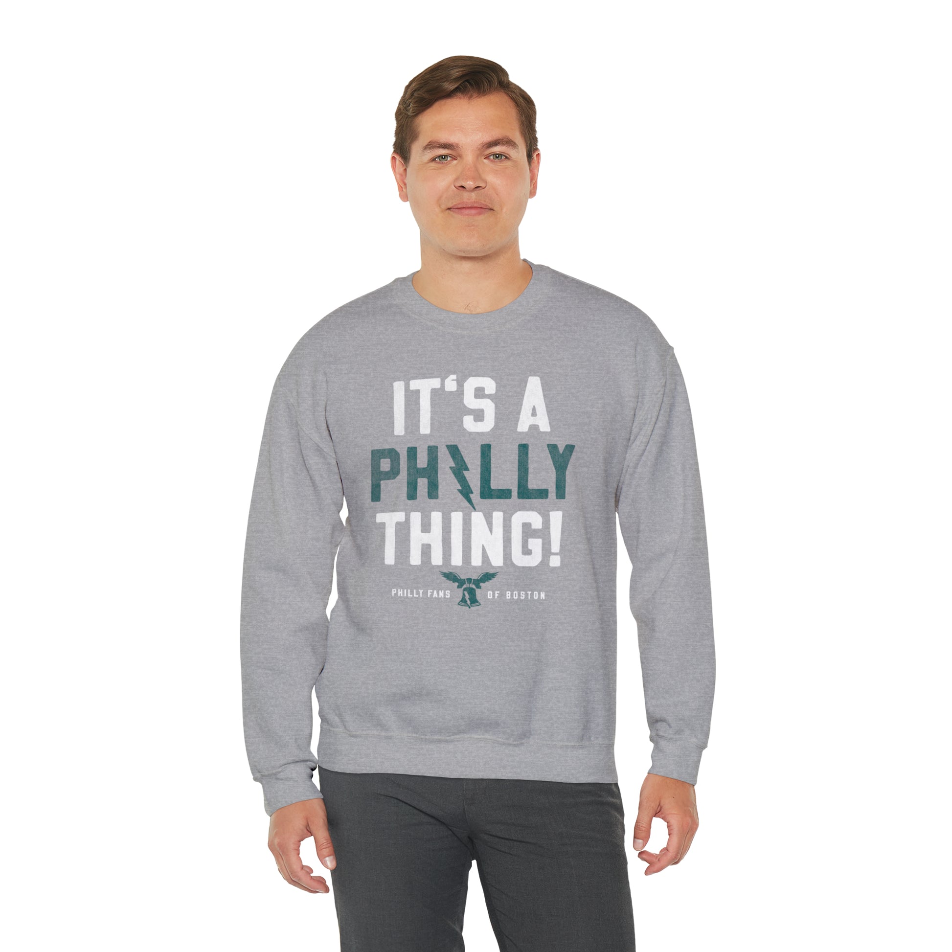 Man wearing a grey heavy blend crewneck sweatshirt with It's A Philly Thing graphic print.