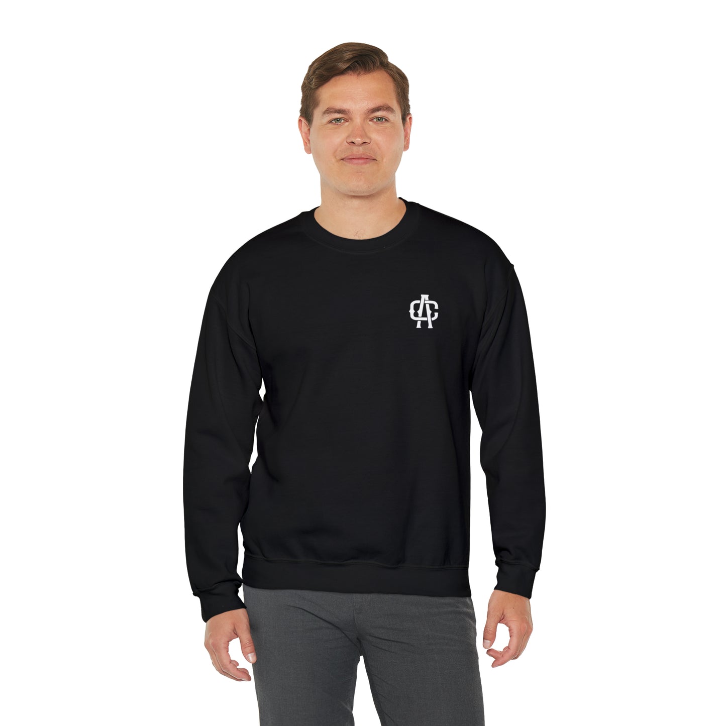 Man wearing a black heavy blend crewneck sweatshirt with a small white logo on the chest, featuring a ribbed collar.