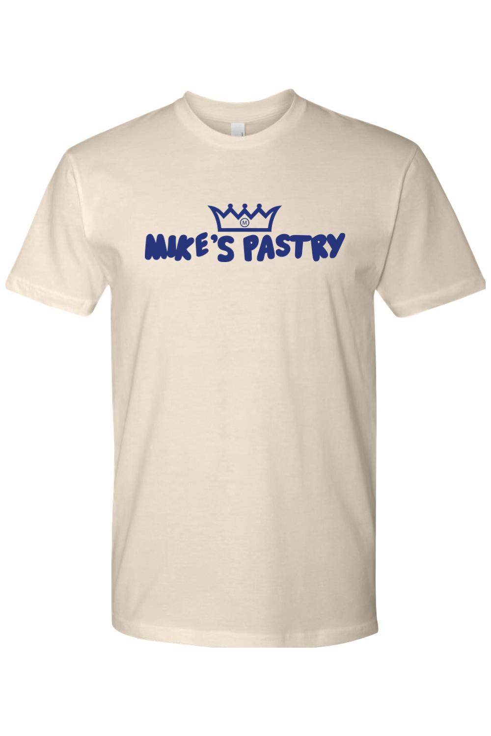 Cream-colored 100% cotton men's t-shirt featuring the blue Mike's Pastry logo and crown graphic on the chest.