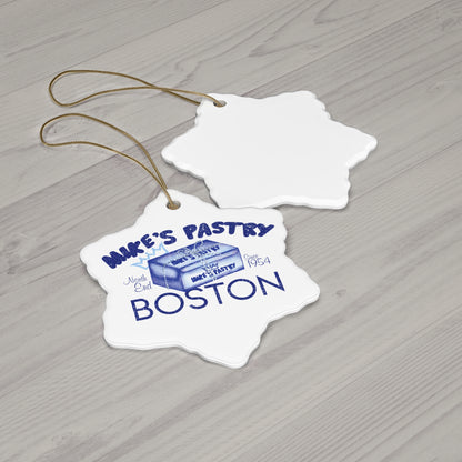 Glossy white ceramic star ornament featuring a blue Mike's Pastry Boston 1954 design with a gold hanging string.