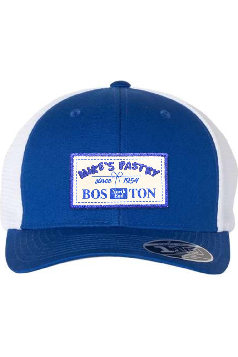 Blue and white Mike's Pastry Flexfit 110 mesh-back cap with a rectangular Boston North End patch on the front.