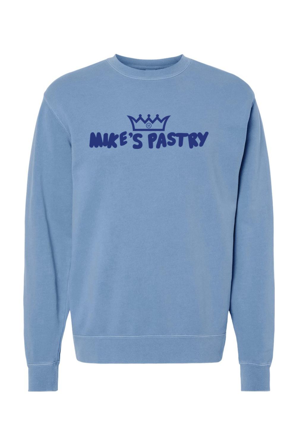 Blue pigment-dyed crewneck sweatshirt with a dark blue Mike's Pastry logo and crown graphic on the chest.