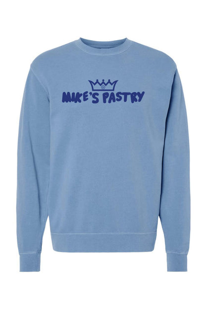 Blue pigment-dyed crewneck sweatshirt with a dark blue Mike's Pastry logo and crown graphic on the chest.