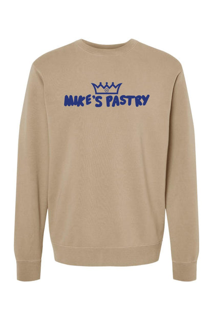 Tan pigment-dyed crewneck sweatshirt with blue Mike's Pastry logo and crown graphic on the chest.