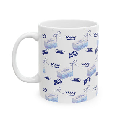 11oz white ceramic mug featuring a blue Mike's Pastry box, crown, and cannoli pattern with a comfortable C-handle.