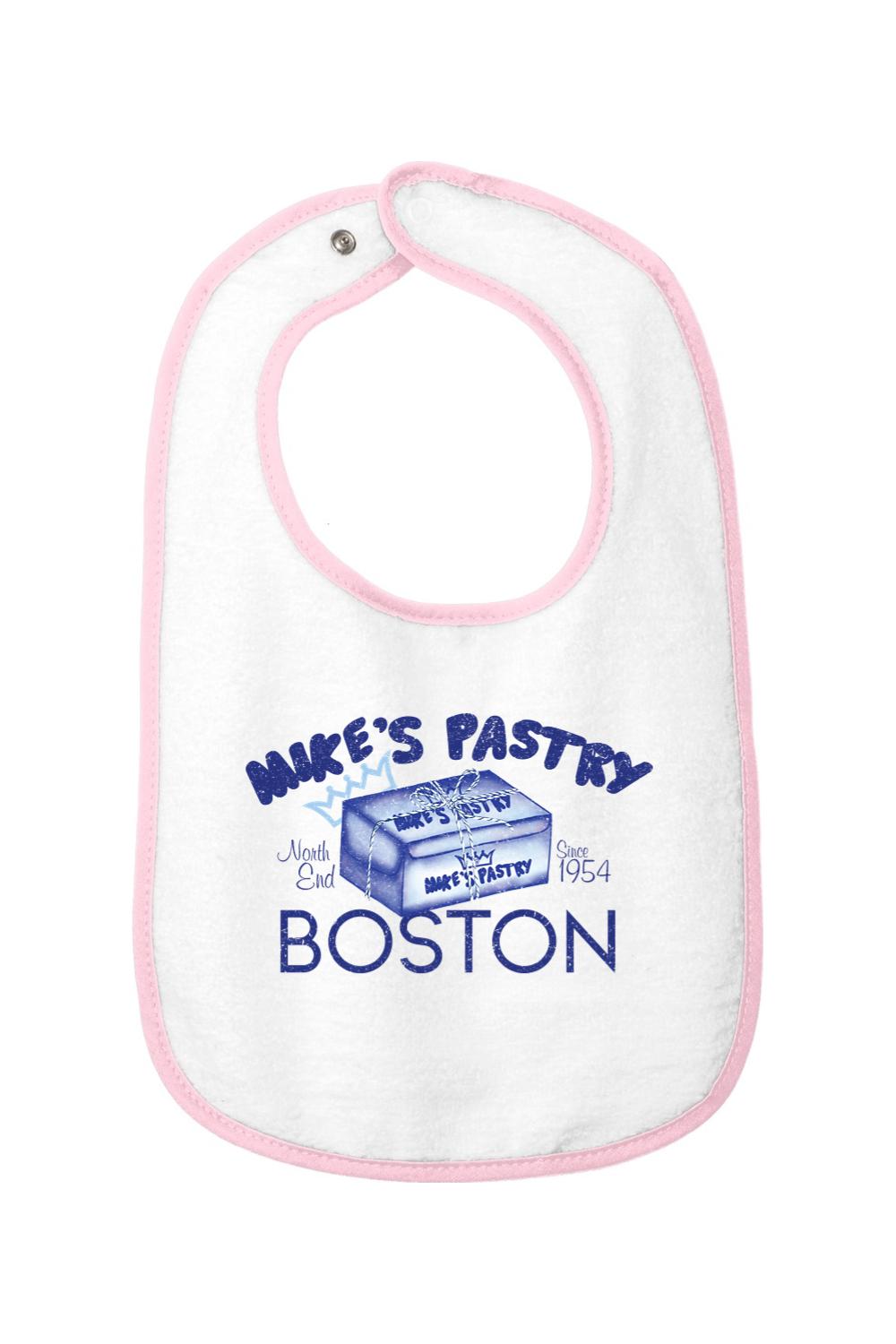 White cotton terry baby bib with pink trim, featuring a blue Mike's Pastry Boston box graphic and hook-and-loop closure.