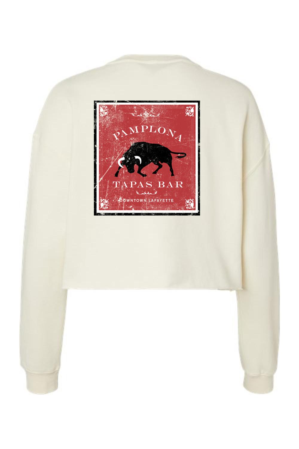 Cream-colored cropped crewneck sweatshirt featuring a distressed red Pamplona Tapas Bar bull graphic on the back.