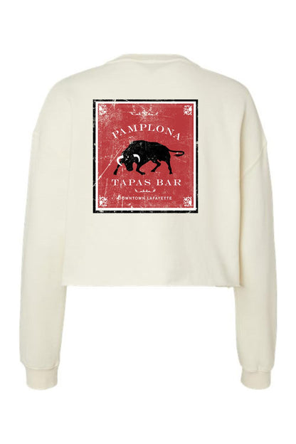 Cream-colored cropped crewneck sweatshirt featuring a distressed red Pamplona Tapas Bar bull graphic on the back.