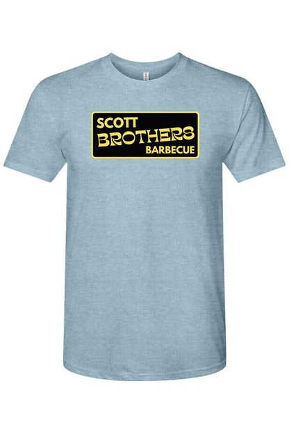 Light blue heathered triblend t-shirt featuring a black and gold Scott Brothers Barbecue logo on the chest.