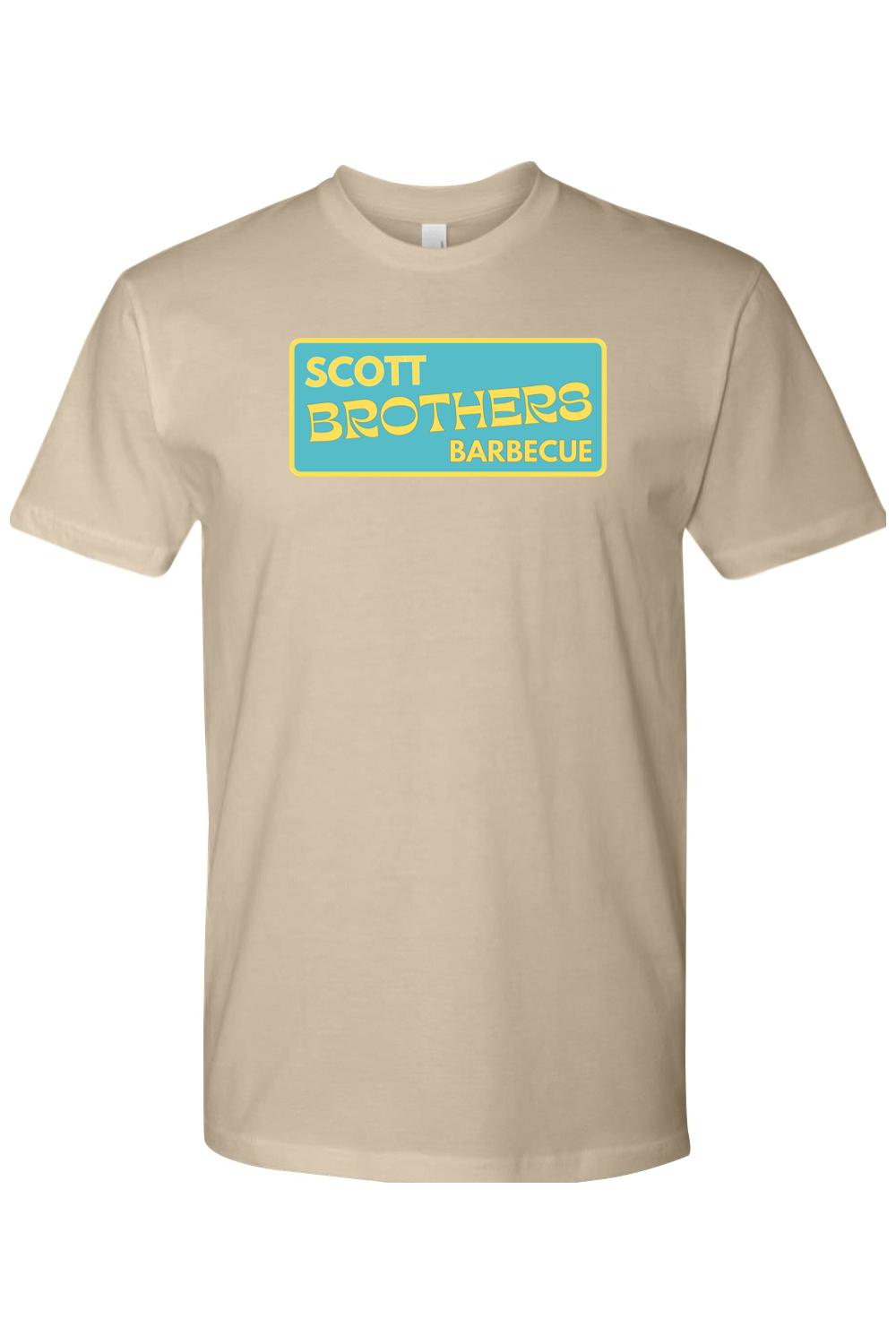 Tan cotton t-shirt featuring a rectangular teal logo with yellow Scott Brothers Barbecue text in a relaxed fit.