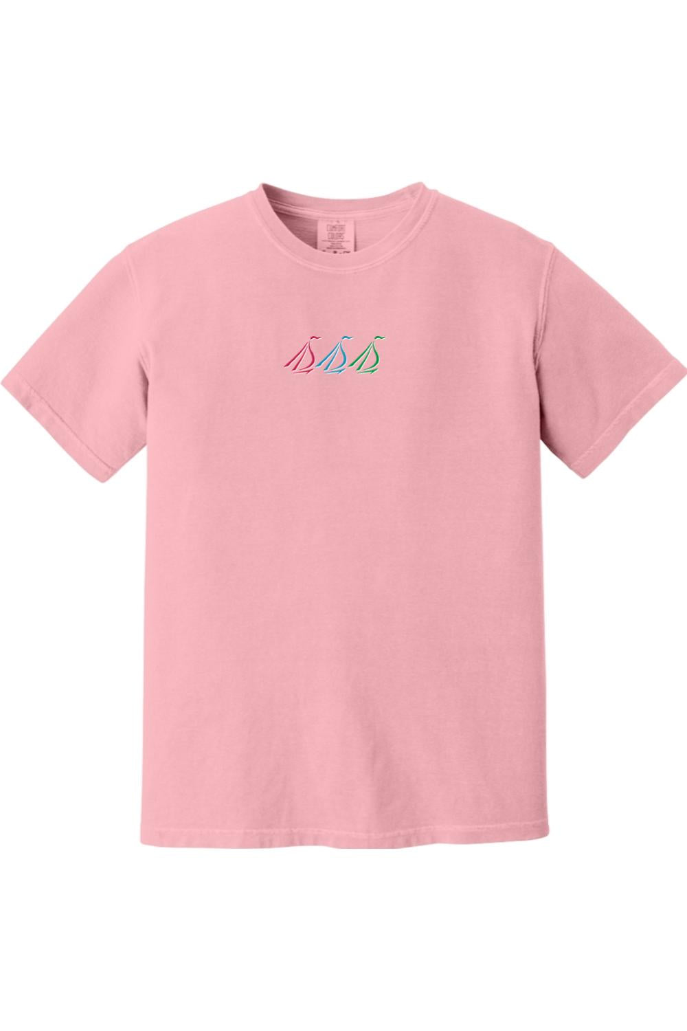 Light pink Comfort Colors unisex t-shirt featuring a small, colorful embroidered tri-sail nautical graphic on the chest.