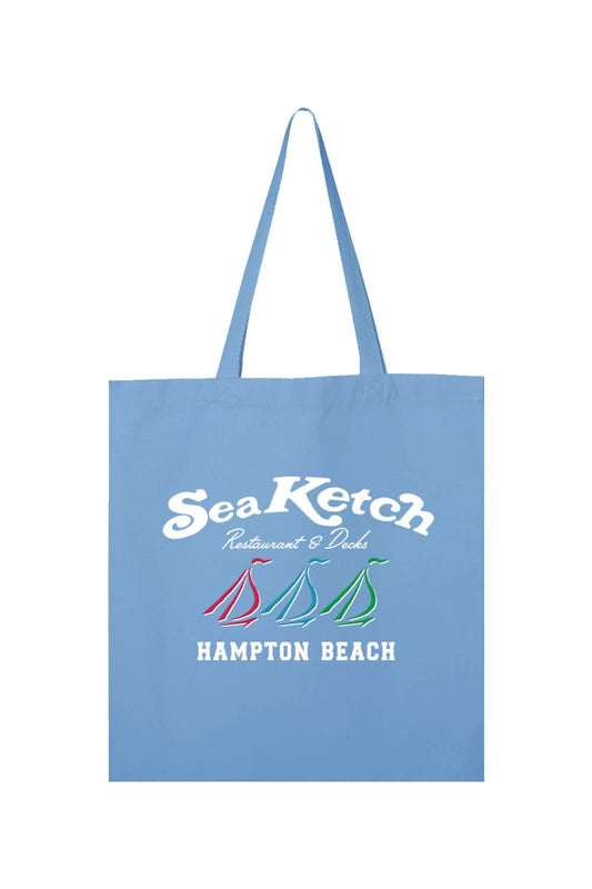 Light blue canvas tote bag featuring a white Sea Ketch Hampton Beach logo and three colorful sailboat icons.