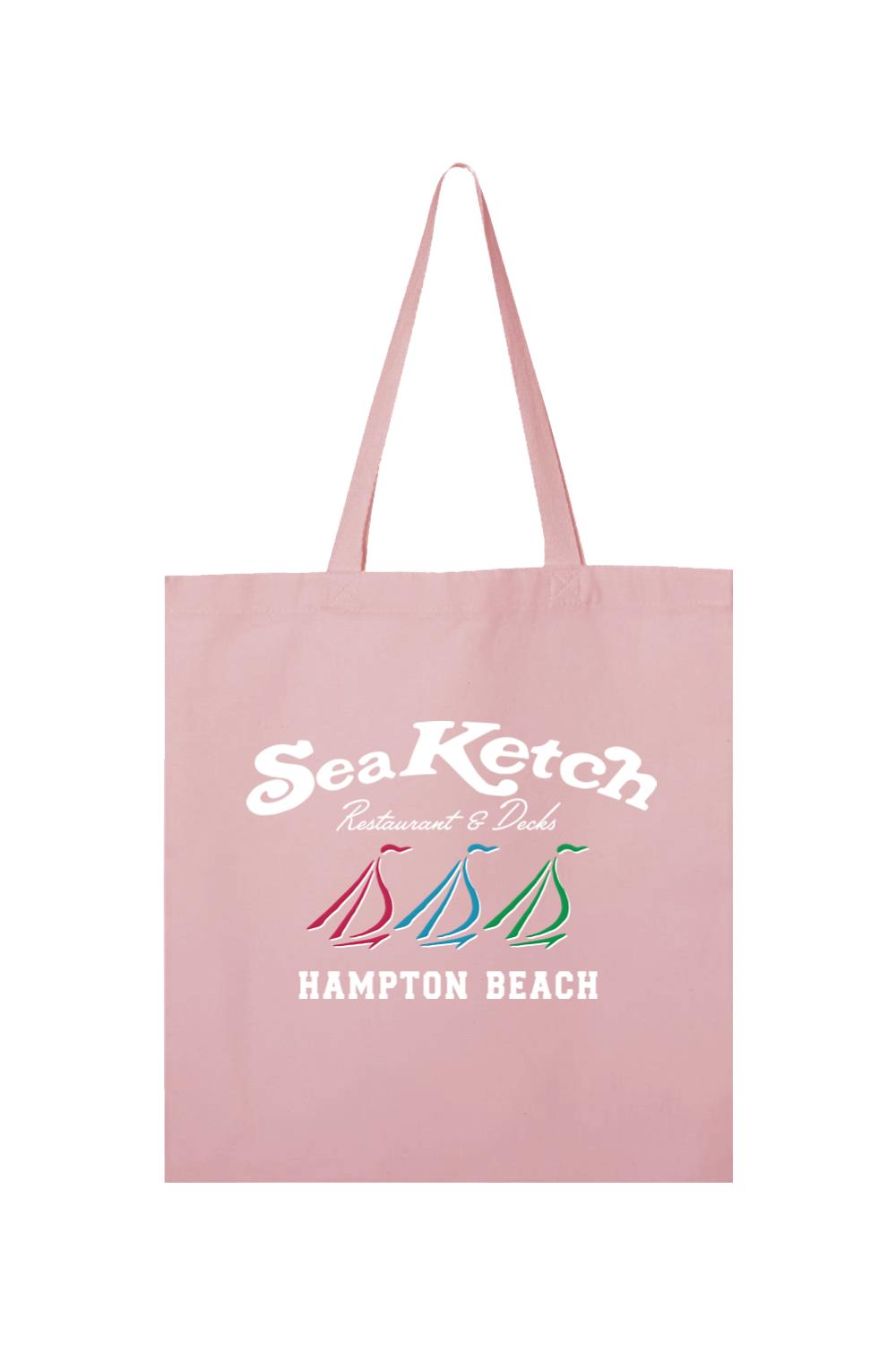 Light pink canvas tote bag featuring a white Sea Ketch logo and three colorful sailboat icons above Hampton Beach text.