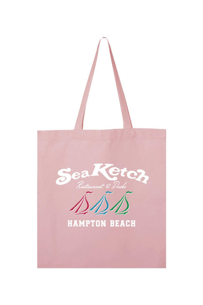 Light pink canvas tote bag featuring a white Sea Ketch logo and three colorful sailboat icons above Hampton Beach text.