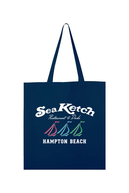 Navy blue canvas tote bag featuring a white Sea Ketch Hampton Beach logo with three colorful sailboat icons.