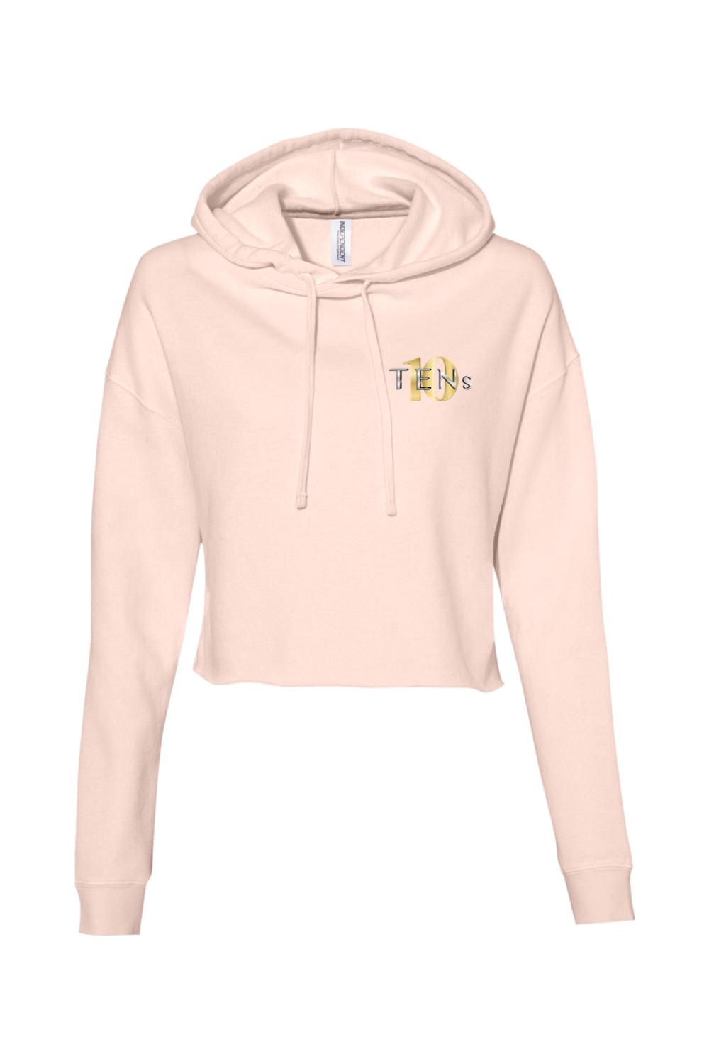 Light pink cropped hooded sweatshirt with long sleeves and a gold TENS logo on the chest.