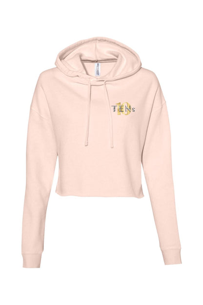 Light pink cropped hooded sweatshirt with long sleeves and a gold TENS logo on the chest.