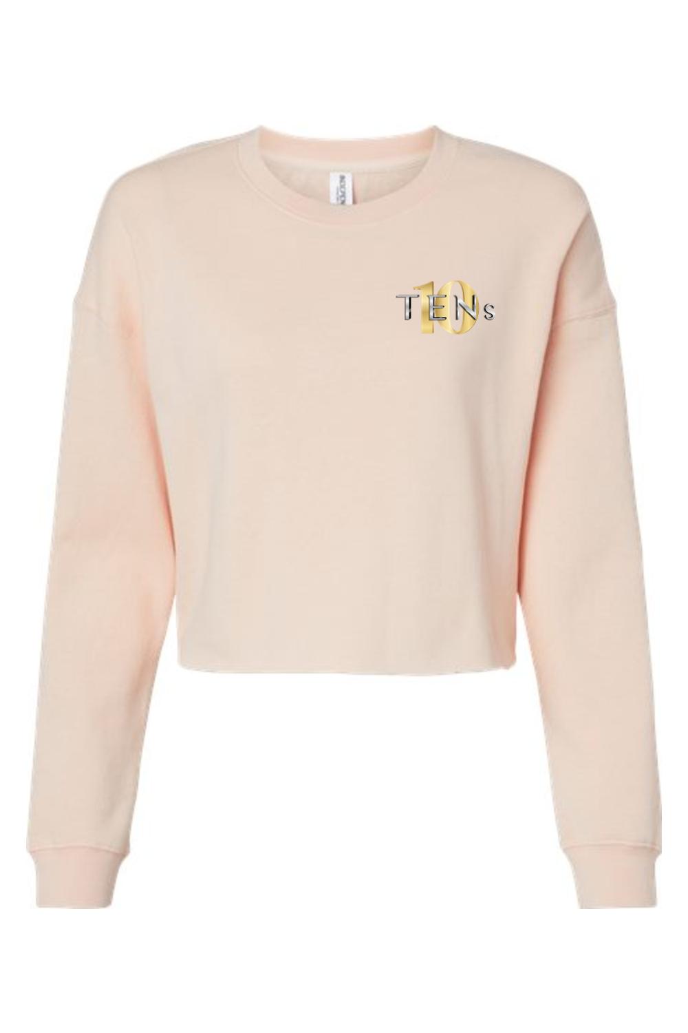 Light peach women's cropped sweatshirt with long sleeves and a gold Tens Show Club logo on the left chest.