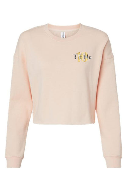 Light peach women's cropped sweatshirt with long sleeves and a gold Tens Show Club logo on the left chest.