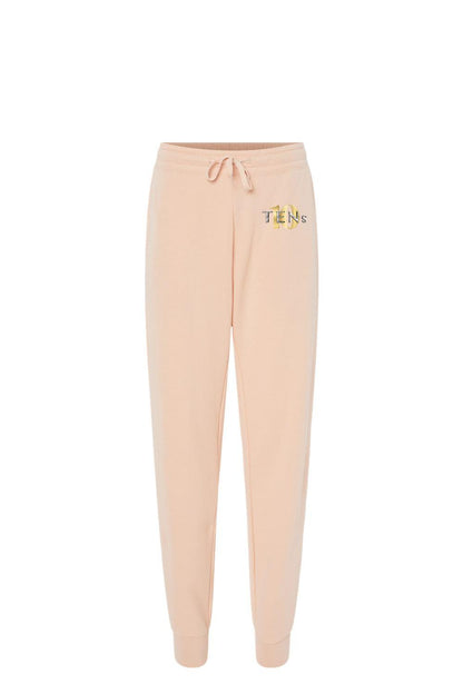 Peach-colored cotton sweatpants with a drawstring waist and gold Tens Show Club logo on the hip.