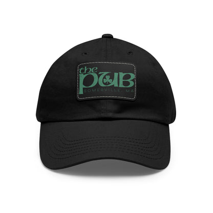 Black unstructured dad hat featuring a faux leather patch with The Pub Somerville logo in green.