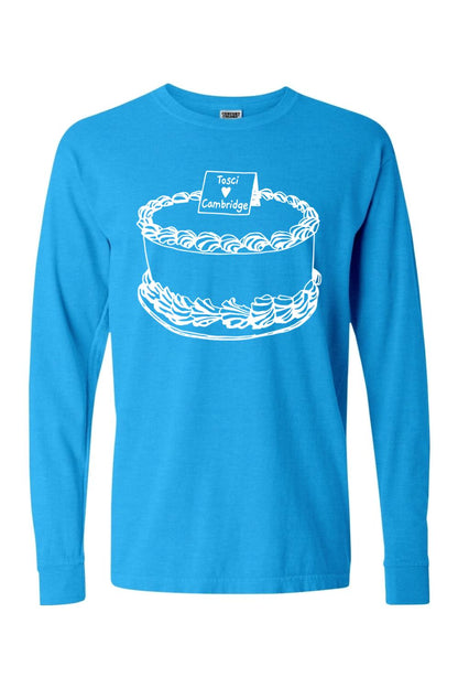 Bright blue Comfort Colors long sleeve tee featuring a white line-art graphic of a cake labeled Tosci Cambridge.