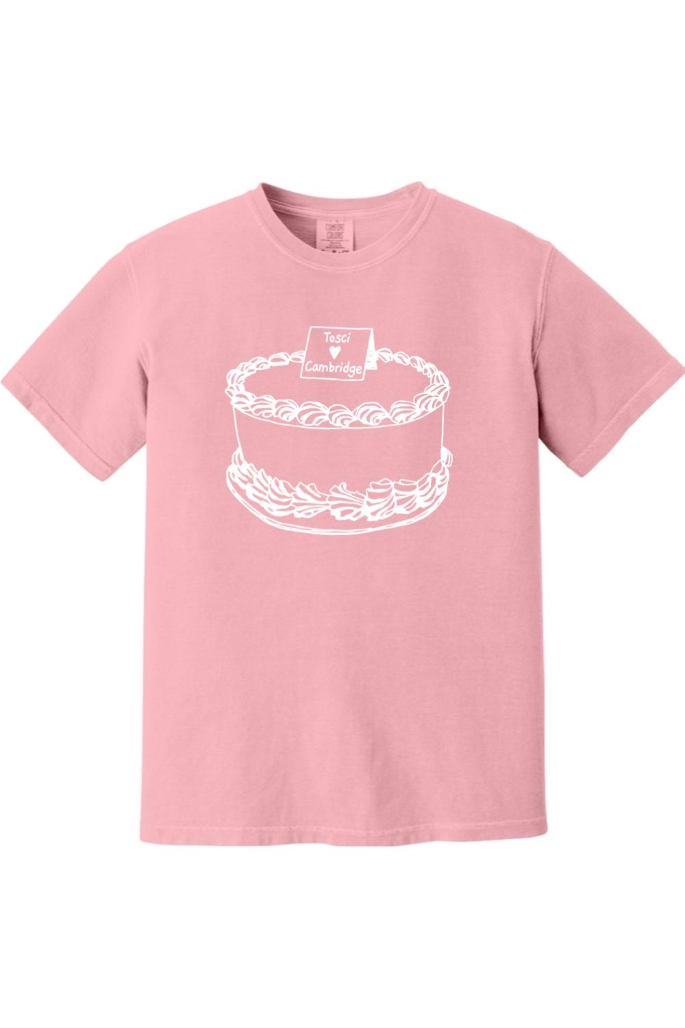 Soft pink Comfort Colors short sleeve t-shirt featuring a white line-art graphic of a cake with a Tosci Cambridge sign.