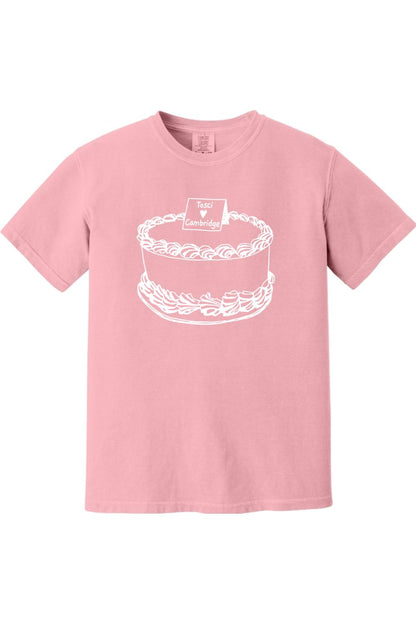 Soft pink Comfort Colors short sleeve t-shirt featuring a white line-art graphic of a cake with a Tosci Cambridge sign.