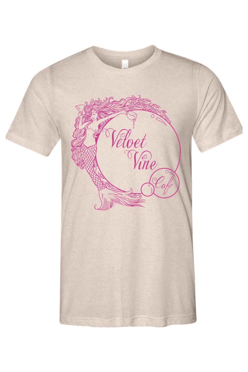 Beige triblend t-shirt featuring a pink mermaid graphic and Velvet Vine Cafe text in a circular bubble design.