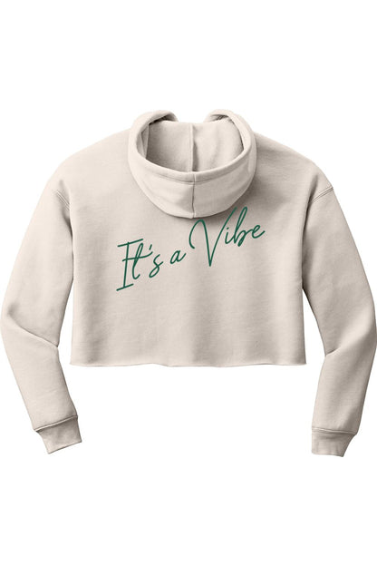 Beige cropped fleece hoodie with a hood and green cursive text on the back that reads It's a Vibe.