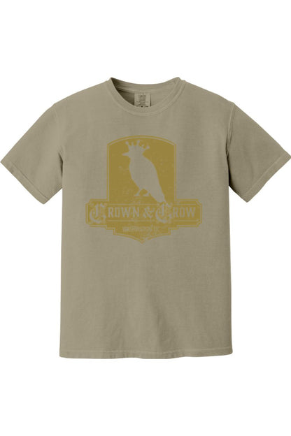 Tan garment-dyed cotton t-shirt featuring a yellow distressed Crown & Crow logo graphic on the chest.